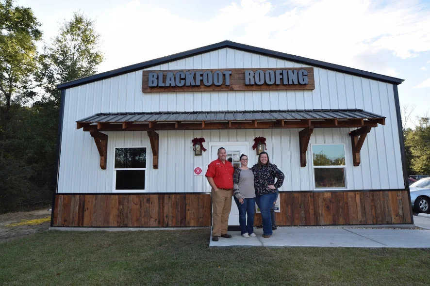 Travis, Amber, and Melissa in front of the Blackfoot Roofing shop in Crawfordville, Florida.