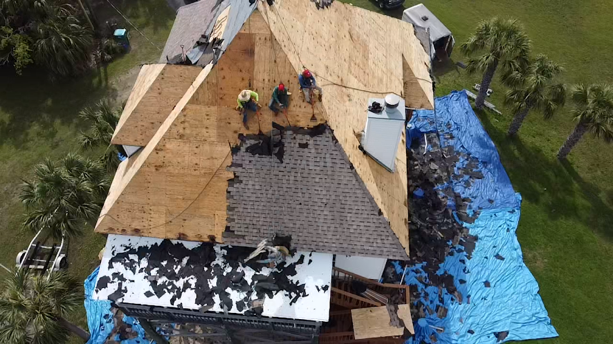 Aerial view of a Blackfoot crew mid tear-off with tarps staged around the home.