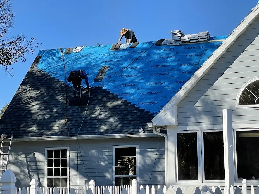 Installers laying shingles over blue Platinum synthetic underlayment.